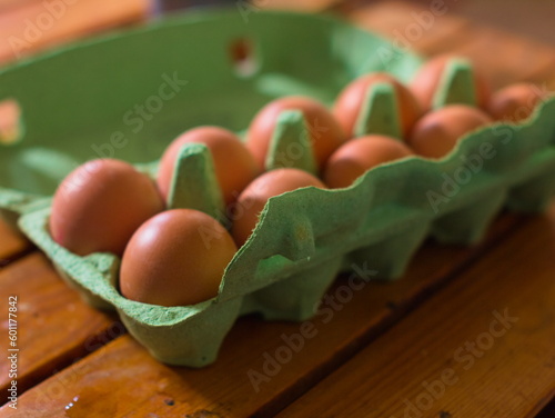 Eggs in a green box on wooden table