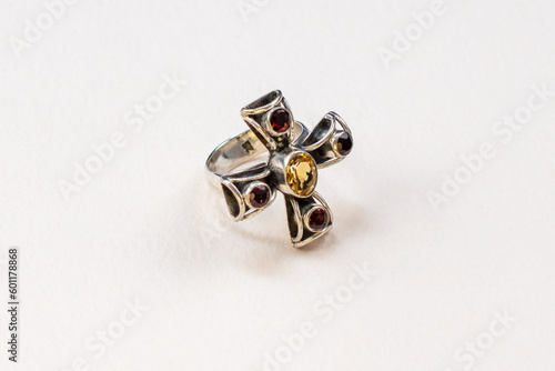 Unique silver cross ring with colorful gemstone crystals on a white background, vintage jewelry concept, promotional photo for an online jewelry store 