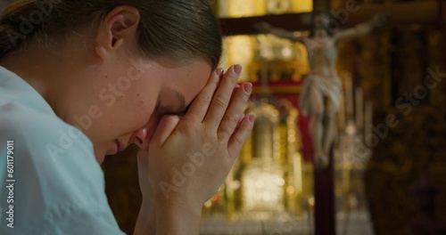 Fototapeta Woman bowed her head in prayer to God in church