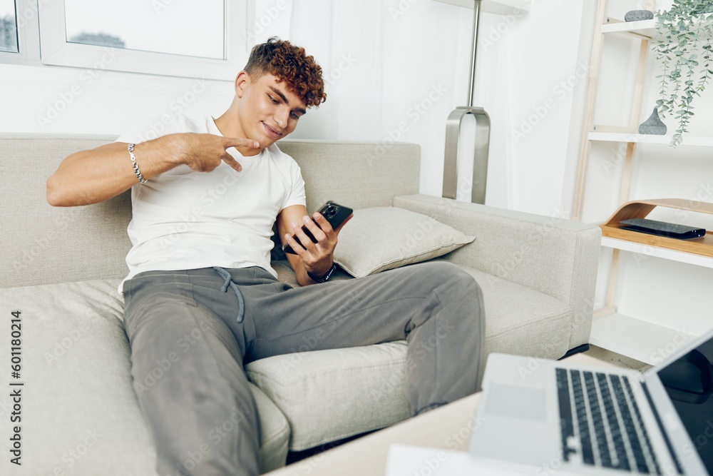Fototapeta premium man interior teenager home sports laptop blogger person smile sofa holding lifestyle adult