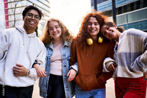 Portrait of happy group of Erasmus students looking at camera smiling. Friends embracing each other while standing outside school. Generation z. © Gigi Delgado