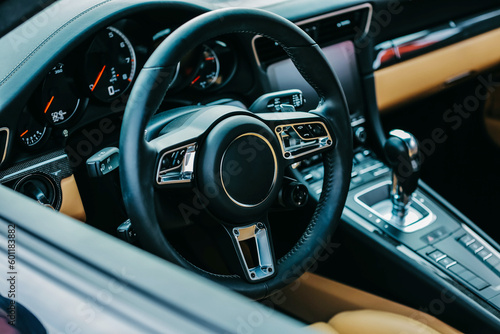 Luxury sports car interior. Steering wheel, shift lever and dashboard. bright leather interior with black dashboard © AvokadoStudio