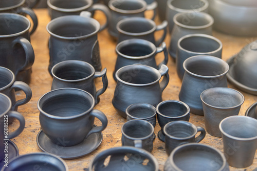 Products from black ceramics of handwork. The craftsman sells many ceramic pots in the market. The concept of a small business for the production of dishes.