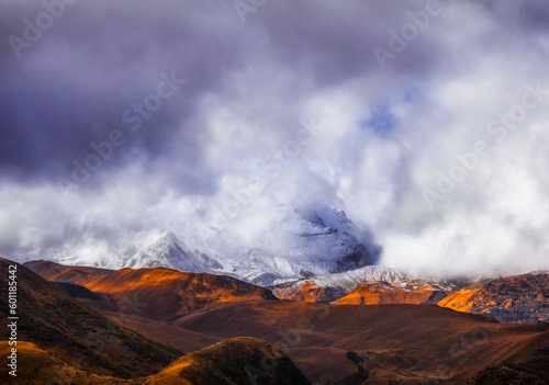 Clouds cover slopes of Kazbegi mountain during sunset time in Georgia Caucasus