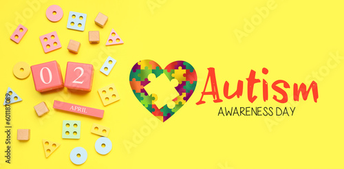 Calendar with date of World Autism Awareness Day and baby toys on yellow background
