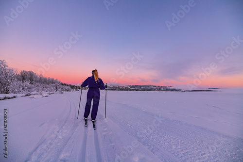 Amazing pastel sunset views along the Yukon River with one person skiing in distance with beautiful winter scenery.