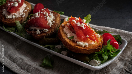 Fotografie Smoked salmon and goat cheese crostini served on a bed of salad greens
