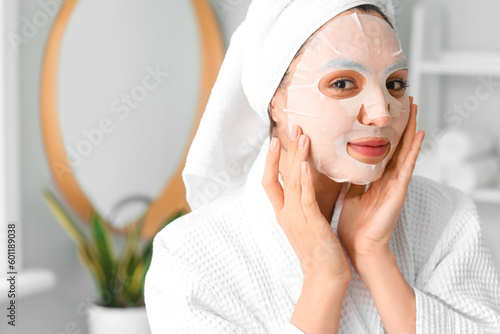 Young woman with sheet mask...
