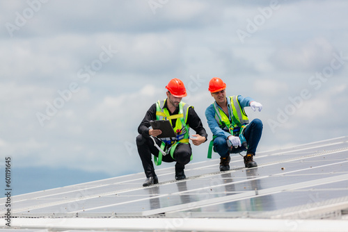 Technician engineer planning to setting solar panel on the roof of the building to work at full efficiency, Using solar cells for energy saving to save and protect environment. Renewable energy