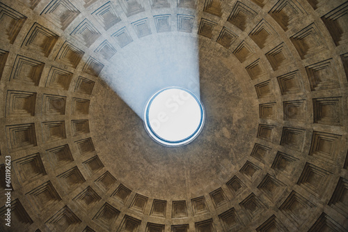 Wnętrze Panteonu w Rzymie z widokiem na imponujący sufit z otworem oculus, przez który wpada światło słoneczne. Ten unikalny widok ukazuje majestatyczną konstrukcję i niesamowite efekty świetlne.
