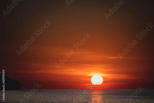 Obraz Zachwycający zachód słońca nad Bałtykiem w miejscowości Władysławowo, Polska. Słońce powoli opada, odbijając swoje ciepłe barwy na spokojnych falach morza.