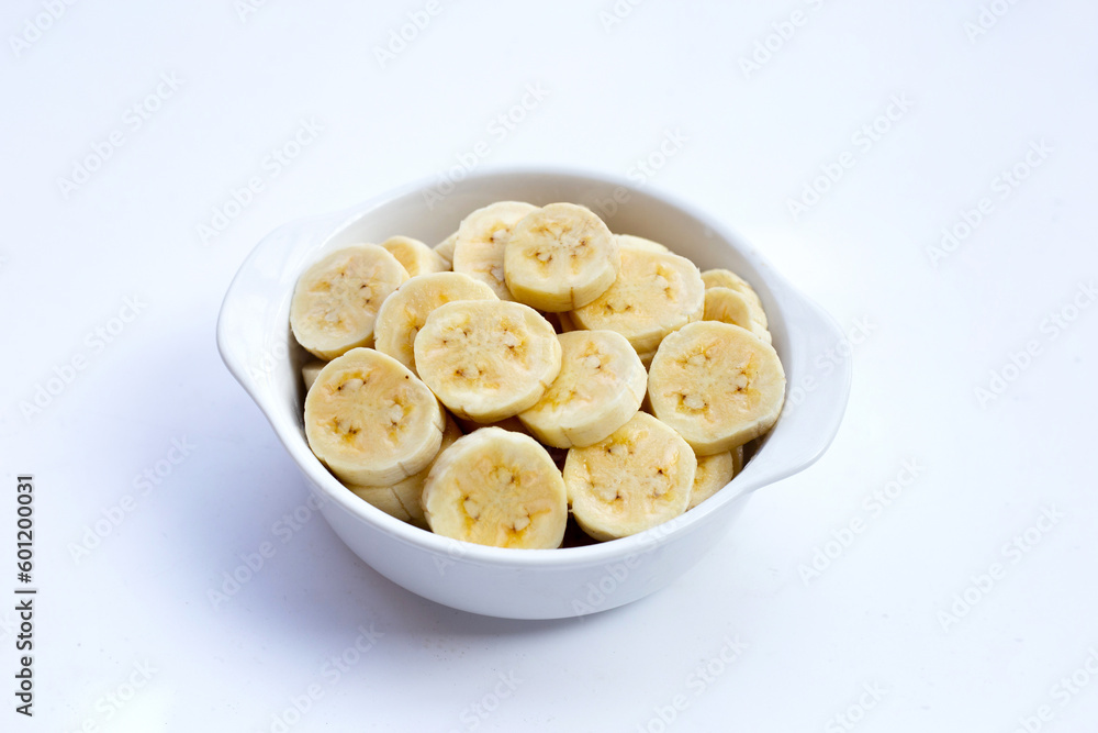 Banana slices in bowl on white background.