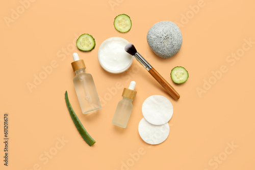 Composition with natural cosmetics, cotton pads, cucumber and aloe leaf on color background