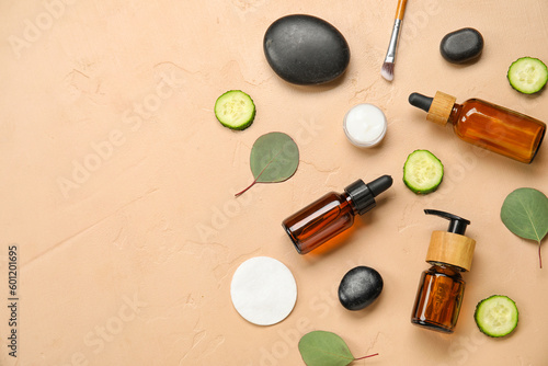 Composition with natural cosmetic products, cucumber and spa stones on color background