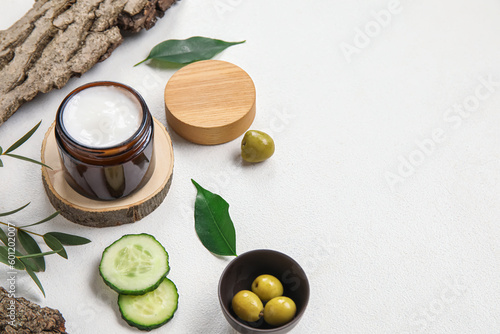 Composition with jar of cream and natural ingredients on light background
