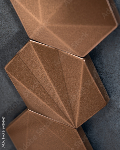 Three Stacked Bronze Tiles Against Gray Background