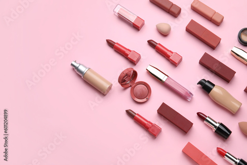 Decorative cosmetics with lipsticks and sponges on pink background