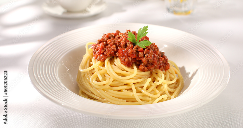 spaghetti bolognese on a white plate. classic italian pasta with meat tomato sauce on a white background. dish of mediterranean cuisine. food on the table on a sunny day. yellow noodles, minced meat. spaghetti bolognese on a white plate. classic italian pasta with meat tomato sauce on a white background. dish of mediterranean cuisine. food on the table on a sunny day. yellow noodles, minced meat.