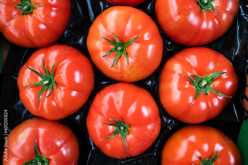 group of ripe red tomatoes in grocery produce 