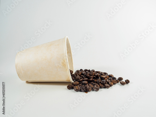 Roasted Arabica coffee beans, ready to make coffee that people like to drink. Placed in a White coffee cup paper on the background. Looks beautiful and appetizing. Drink.