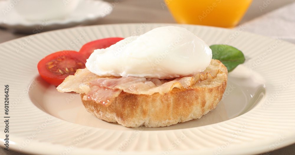 poached egg with bacon on a plate. boiled egg on bread with sauce. delicious breakfast with vegetables. serving food on a sunny day. poached egg with bacon on a plate. boiled egg on bread with sauce. delicious breakfast with vegetables. serving food on a sunny day.