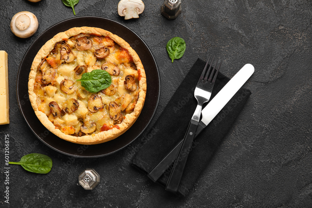 Mushroom pie with spinach leaves and cutlery on black grunge table Mushroom pie with spinach leaves and cutlery on black grunge table