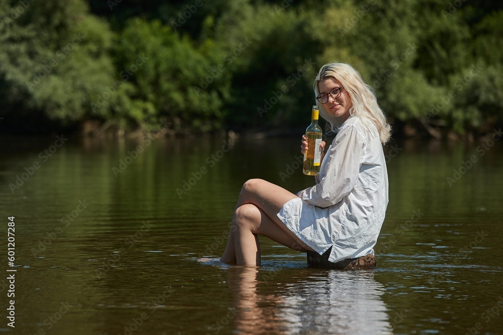 Woman on a river with bottle of wine Woman on a river with bottle of wine