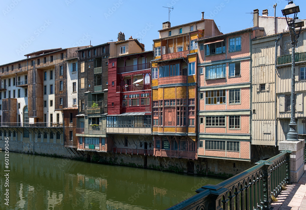 Charming houses line the river Agout in Castres, France, showcasing stunning architecture and beautiful reflections in the water. A picturesque and peaceful scene to admire. Charming houses line the river Agout in Castres, France, showcasing stunning architecture and beautiful reflections in the water. A picturesque and peaceful scene to admire.