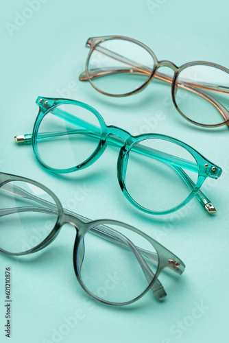 Different new eyeglasses on pale turquoise background