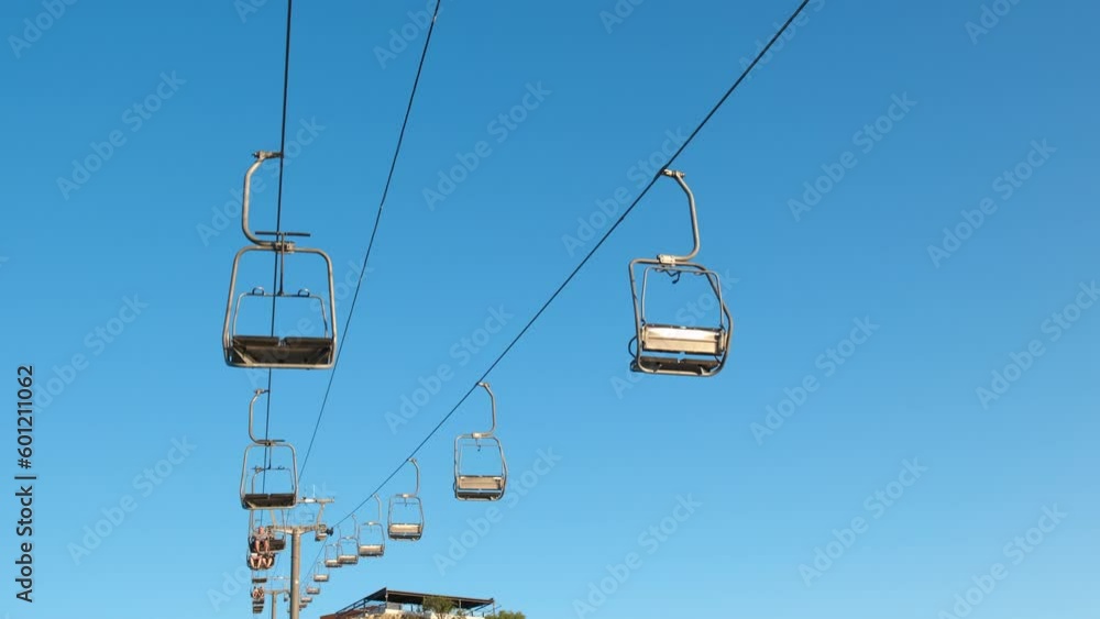 Lonely chairlifts in the summer sky. A view of lonely chairlifts against clear blue sky in summer. Lonely chairlifts in the summer sky. A view of lonely chairlifts against clear blue sky in summer.