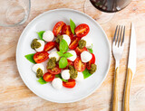 Caprese salad with basil and pesto sauce served on plate. Traditional Italian salad.