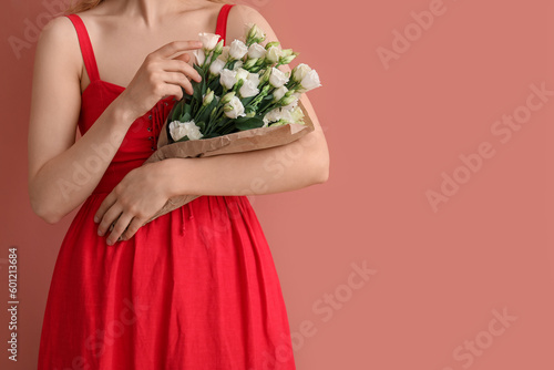 Fototapeta Naklejka Na Ścianę i Meble -  Young woman with bouquet of beautiful eustoma flowers on pink background