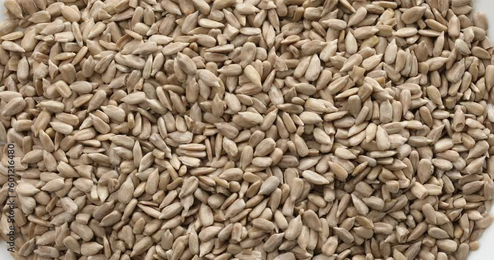 Peeled sunflower seeds close-up. unroasted nuts rotate and zoom. natural vegan food. walnut background. High quality 4k footage Peeled sunflower seeds close-up. unroasted nuts rotate and zoom. natural vegan food. walnut background. High quality 4k footage