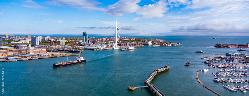 Obraz premium Aerial view of Portsmouth Harbor in the south of England on the Channel coast - Oil tanker passing in front of the sail-shaped Spinnaker Tower