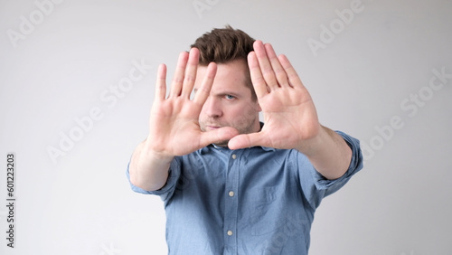 European young man shows a stop sign with his hands