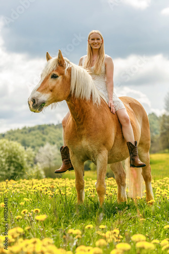 A young woman enjoying time with her haflinger horse in spring outdoors. Female equestrian friendship scene with her horse © Annabell Gsödl