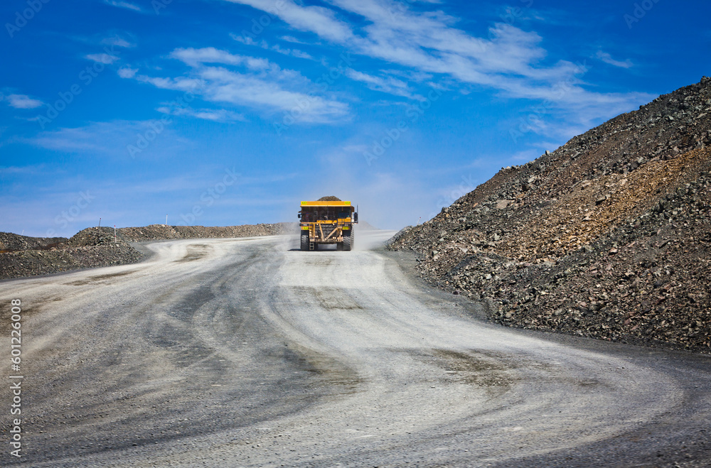Massive trucks are used to transport mining ore. Open-cast gold mine in Australia.