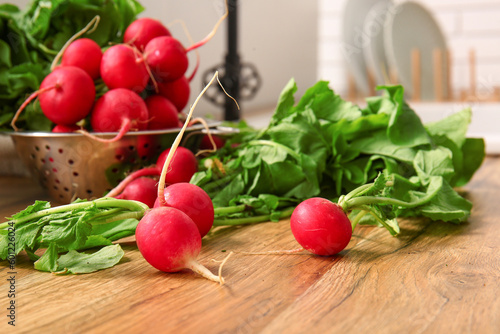 Fresh radish with green leaves on table in kitchen