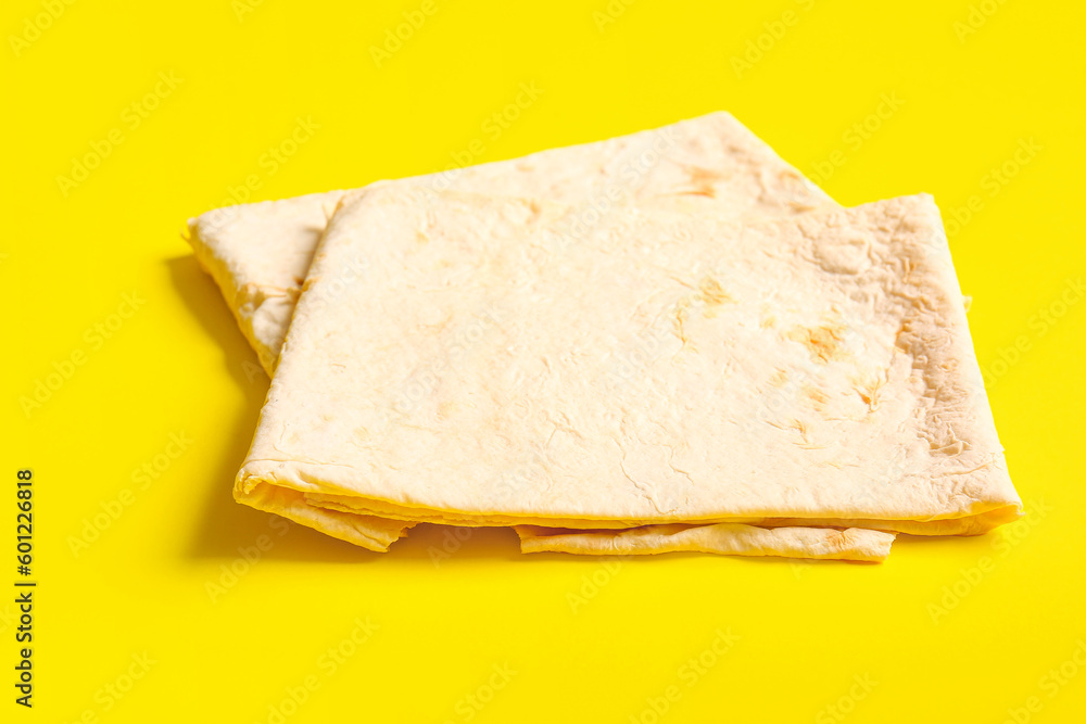 Fresh thin lavash on yellow background