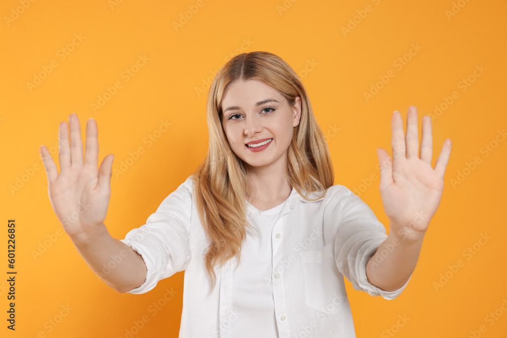 Happy woman giving high five with both hands on orange background Happy woman giving high five with both hands on orange background
