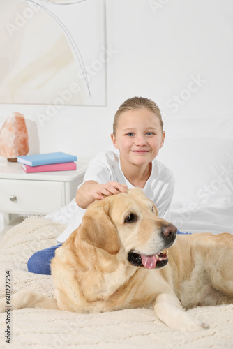 Fototapeta Naklejka Na Ścianę i Meble -  Cute child with her Labrador Retriever on bed at home. Adorable pet