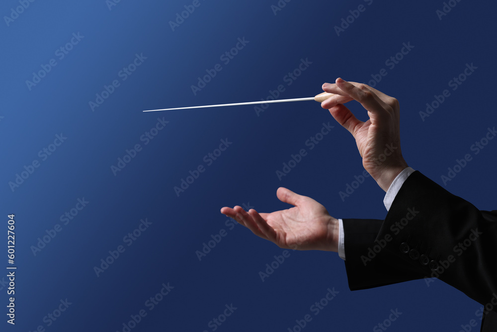 Professional conductor with baton on blue background, closeup - obrazy, fototapety, plakaty 