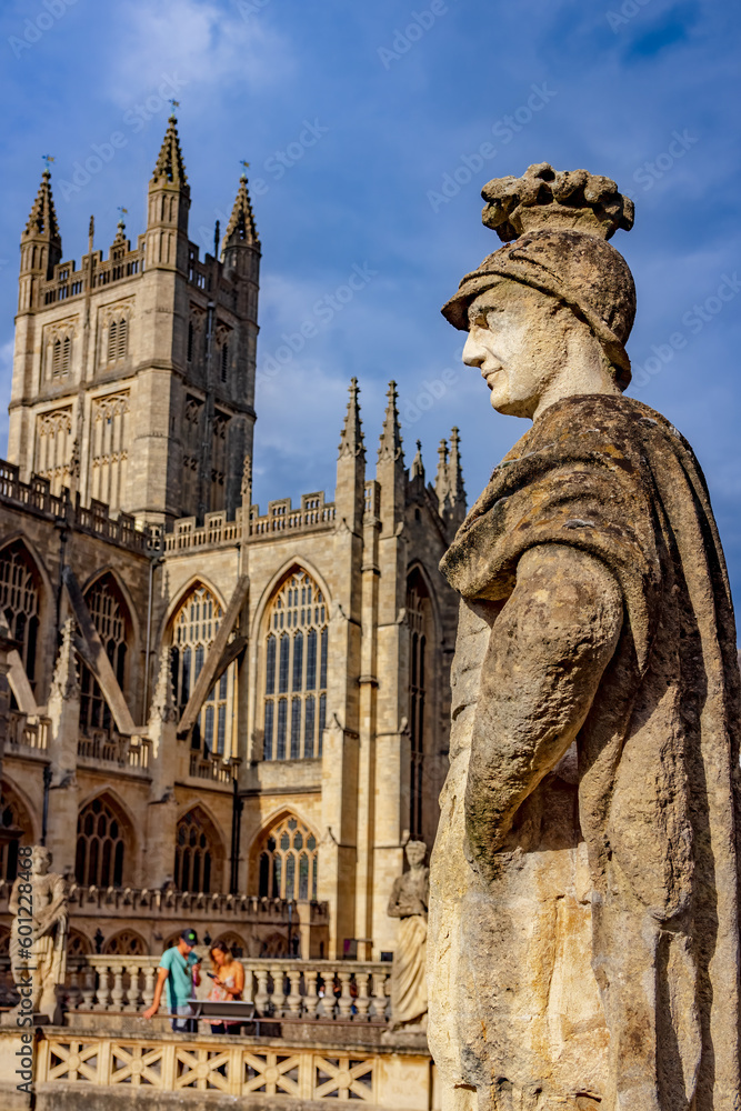 Statue at the ancient Roman baths with the Abbey in Bath, England.