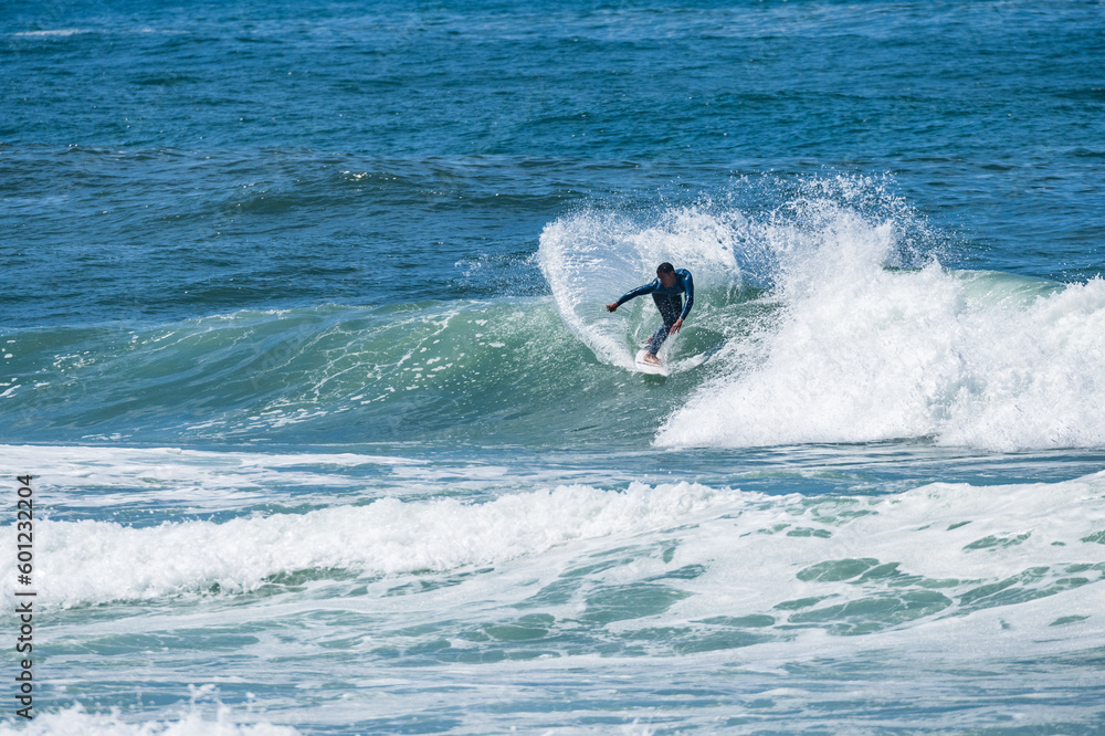 Fototapeta premium Young athletic surfer rides the wave