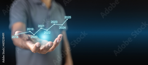 Target growth to year 2025 concept. Graph growth strategy year 2018 to 2025 on a hand businessman. Chart plan management economic finance marketing goal future.
