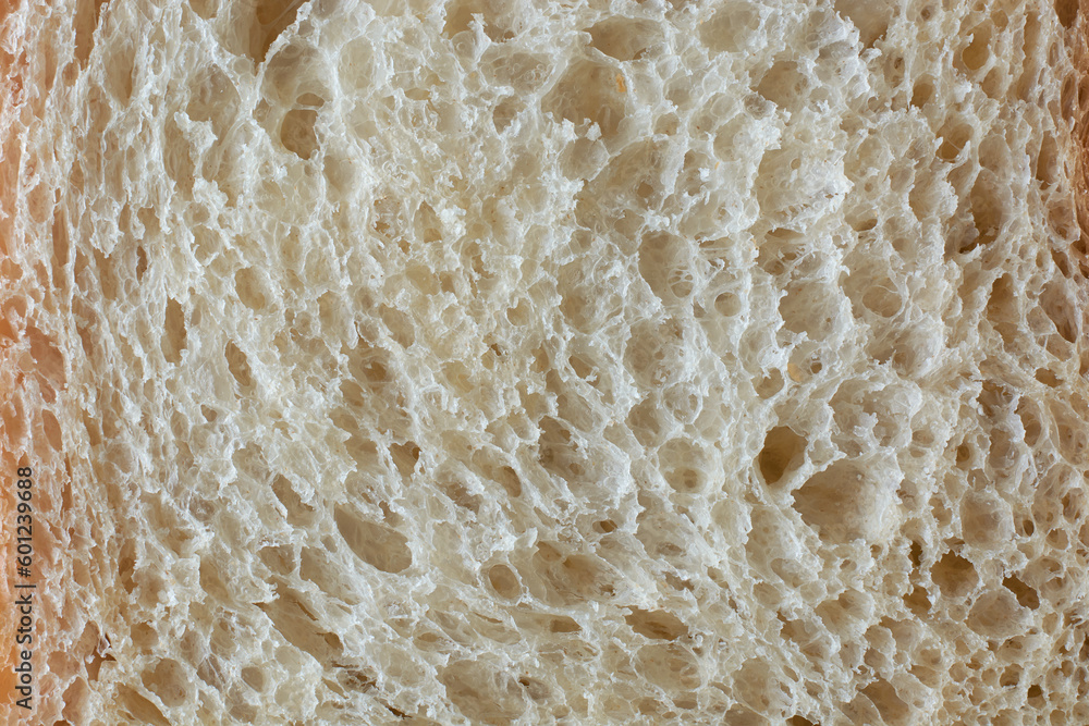 surface of white bread in full frame, popular food item in many cultures and used for making sandwiches, toast, and other dishes, lighter color and softer texture food background