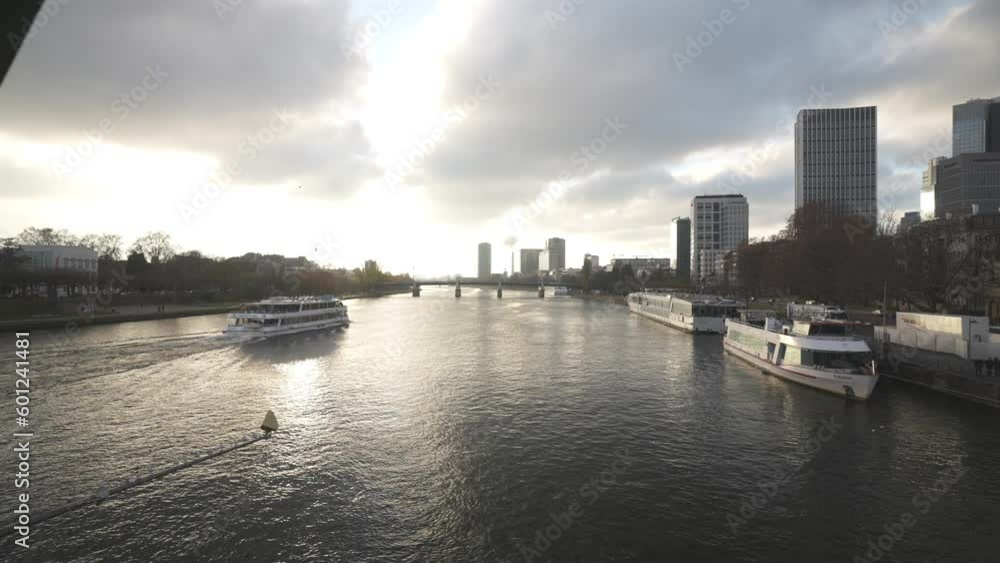 Cruise boat on Main River and city skyline at golden hour, Frankfurt am Main, Hesse Cruise boat on Main River and city skyline at golden hour, Frankfurt am Main, Hesse