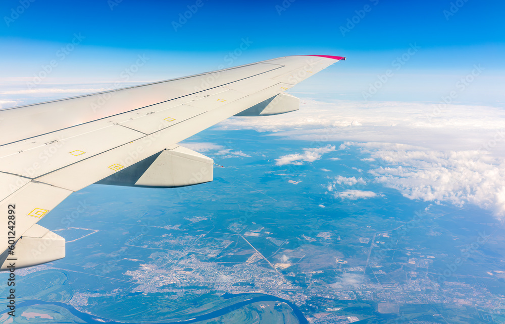 View from the airplane window at a beautiful cloudy sky and the airplane wing View from the airplane window at a beautiful cloudy sky and the airplane wing