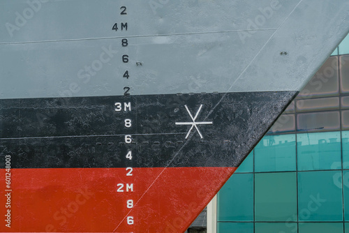 Depth gauge on side of naval ship in dry dock.