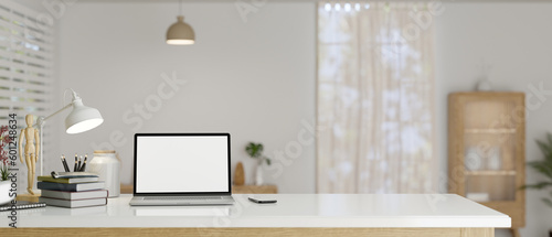 A study table in a minimal Scandinavian room with laptop mockup and copy space